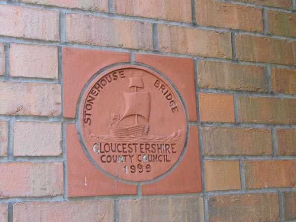 The terracotta plaque shows a relief of a trow under sail and bears the words Stonehouse Bridge.